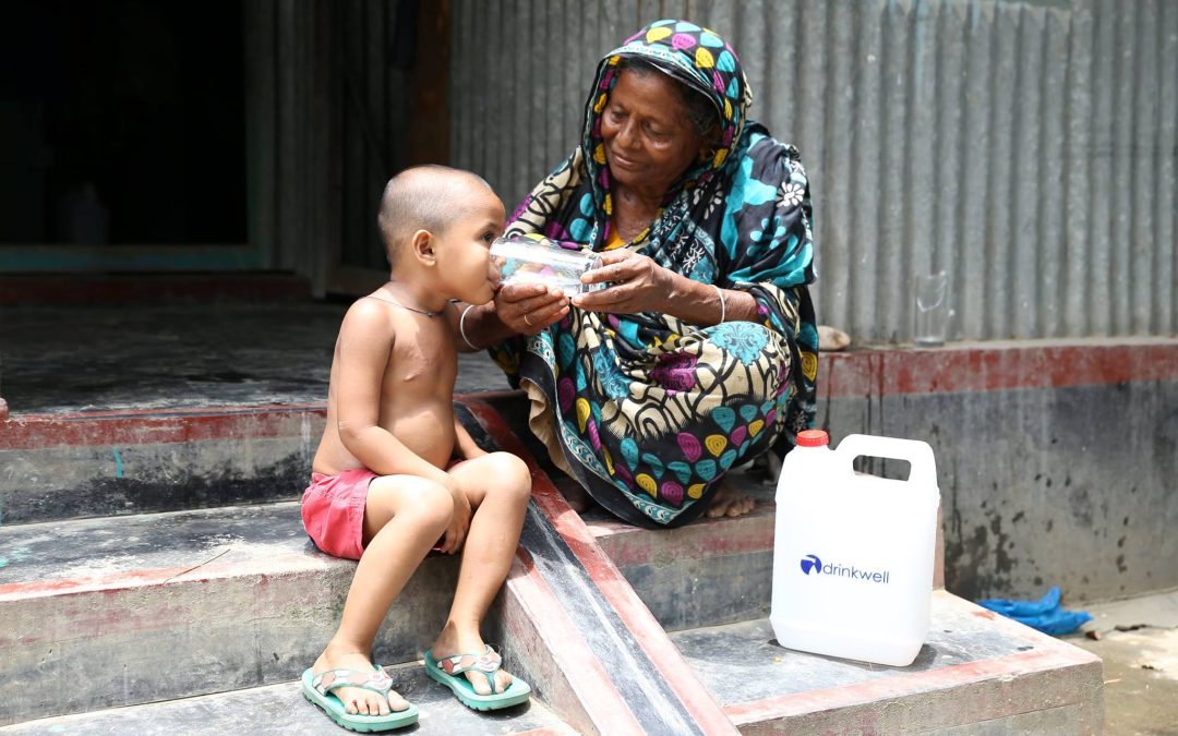 Drinkwell photo of woman giving water to a child